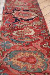 Cherry red antique Serapi runner with sapphire blue palmettes and scrolling floral motifs, showing mostly even wear.