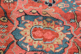 Antique Serapi rug: cherry red palmette, sapphire blue leaves, and visible pile wear.