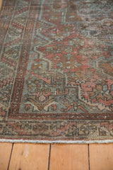 Distressed Malayer rug showing worn serrated leaf pattern in dusty red and denim blue.