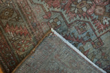 Corner of vintage distressed Malayer rug showing worn pile, muted patterns, and visible foundation weave.