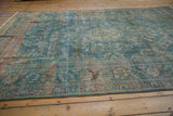 Time-softened dusty denim blue and raspberry red floral patterns on a vintage distressed Malayer carpet.