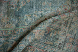 Distressed vintage Malayer carpet showing worn pile, faint foundation, and muted blue-red tones.