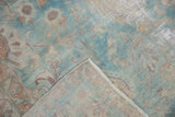 Folded corner of vintage Yazd carpet, showing powder blue floral pile and hand-knotted foundation.