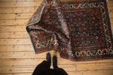 Rolled corner of the hand-knotted Vintage Tajabad rug, showing Herati motif in deep navy and red.