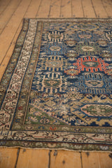 Repeating madder red, navy, and ivory palmette motifs on a Vintage Malayer rug.