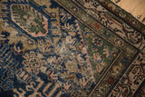 Vintage Malayer rug detail: worn meandering vine border in navy blue, green, and antique ivory.