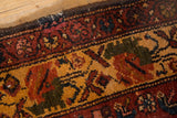 Vintage Malayer rug detail: large scale floral main border in deep gold, blush, and mallard green, showing knot heads.
