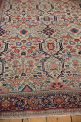 Antique Farahan Sarouk rug's repeating samovar turtle and floral motifs, deep navy border.