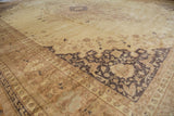 Distressed vintage Sivas carpet displaying an ornate dark charcoal border and subtle beige floral field.
