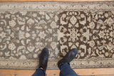 Distressed vintage rug pile with contrasting charcoal and dark brown tones.