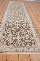 Distressed vintage Hamadan runner texture with charcoal, ivory floral and vinery motifs.