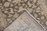 Folded corner of a distressed Hamadan rug, exposing allover floral pile and hand-knotted foundation.