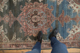 Distressed Malayer rug with roundel medallion, scrolling contour, and abrashed field.