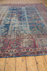 Vintage Yezd carpet border detail with raspberry red blossoms and worn indigo field.