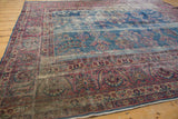Vintage Persian Yezd carpet detail: raspberry red and indigo blue border with vinery and worn knot heads.