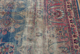 Heavily worn vintage Yezd carpet with exposed foundation, faded blue and red floral vinery.