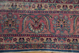 Intricate blossoms and worn pile in raspberry and blue on a vintage Yezd carpet.