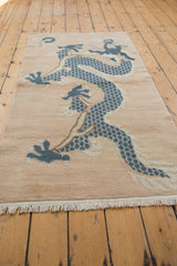 Close-up of dusty blue dragon scales and even pile texture on a distressed Tibetan rug.