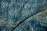 Distressed vintage Peking carpet showing worn texture, exposed foundation, and soft blue hues.