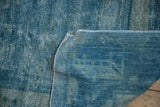Distressed vintage Peking carpet showing wear to foundation and pale blue selvage.