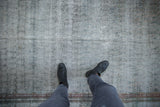 The distressed texture and muted dusty teal tones of a vintage Malayer carpet viewed from above.