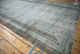 The characteristic worn texture of a distressed vintage Malayer carpet in faded teal.
