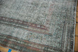 Visible knot heads and foundation on the corner of the distressed vintage Malayer carpet.