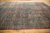 Vintage distressed Persian Meshed carpet border detail with scrolling vinery, splayed florals, and dusty cochineal, navy, beige tones.