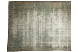 Vintage distressed Kerman carpet with faded floral field and vine borders in muted green-blue and ivory.