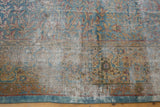 Textured distressed Kerman carpet revealing visible foundation and faded blue, gold, red motifs.