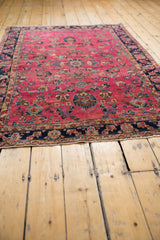 Bursting floral motifs in raspberry red, navy, and sky blue on a vintage Sarouk rug.