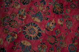 Sarouk rug detail: raspberry red field, large navy, blush, and beige floral cross-sections.