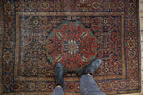 Antique Persian Farahan Sarouk rug featuring navy, madder red, green, Herati field, and even wear.