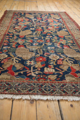 Vintage Hamadan rug detail: navy, red, beige pomegranate pattern, worn pile texture.