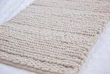 Textured undyed pure wool pile of a handmade Snow Collection rug.