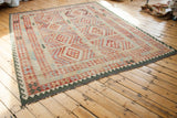 New Kilim rug lower right corner, brilliant geometric patterns and dark green border.
