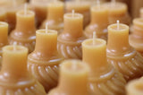 Amber beeswax candles with a distinct swirl texture, molded from antique inkwell bottles.