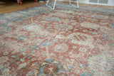 Close perspective on the distressed texture and faded palmettes of a vintage Tabriz carpet.