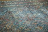 Distressed texture of a vintage Joshegan rug with sapphire and ruby floral motifs.