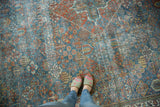 Distressed vintage Joshegan rug with intricate botanical motifs in sapphire and ruby tones.