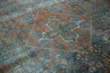 Intricate distressed Joshegan rug featuring a quatrefoil medallion and botanical motifs in gem tones.