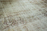 Textured surface of the antique distressed Kermanshah rug, with exposed foundation and faded motifs.