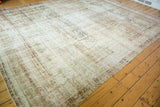 Decorative distressed texture on an antique Kermanshah carpet, showing exposed foundation and softened hues.