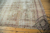 Distressed antique Kermanshah carpet showing faded mille fleur field and exposed foundation.