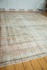 Decorative distressed antique Kermanshah rug featuring softened blush, ivory, and faded floral patterns.