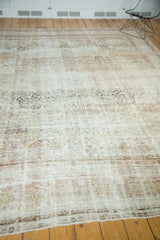 Distressed antique Kermanshah rug showing foundation and a faded, intricate floral design.