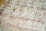 Distressed antique Kermanshah carpet's worn texture, knot heads, and faded blush ivory patterns.