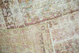 Close-up of the antique distressed Kermanshah carpet, showing exposed foundation and faded pile texture.