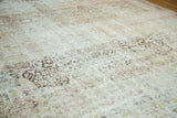 Distressed antique Kermanshah carpet detail: faded intricate patterns, worn knot heads in ivory, blush, charcoal.