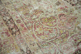 Distressed mil fleur pattern of antique Kermanshah showing blush, saffron, and ivory tones.
